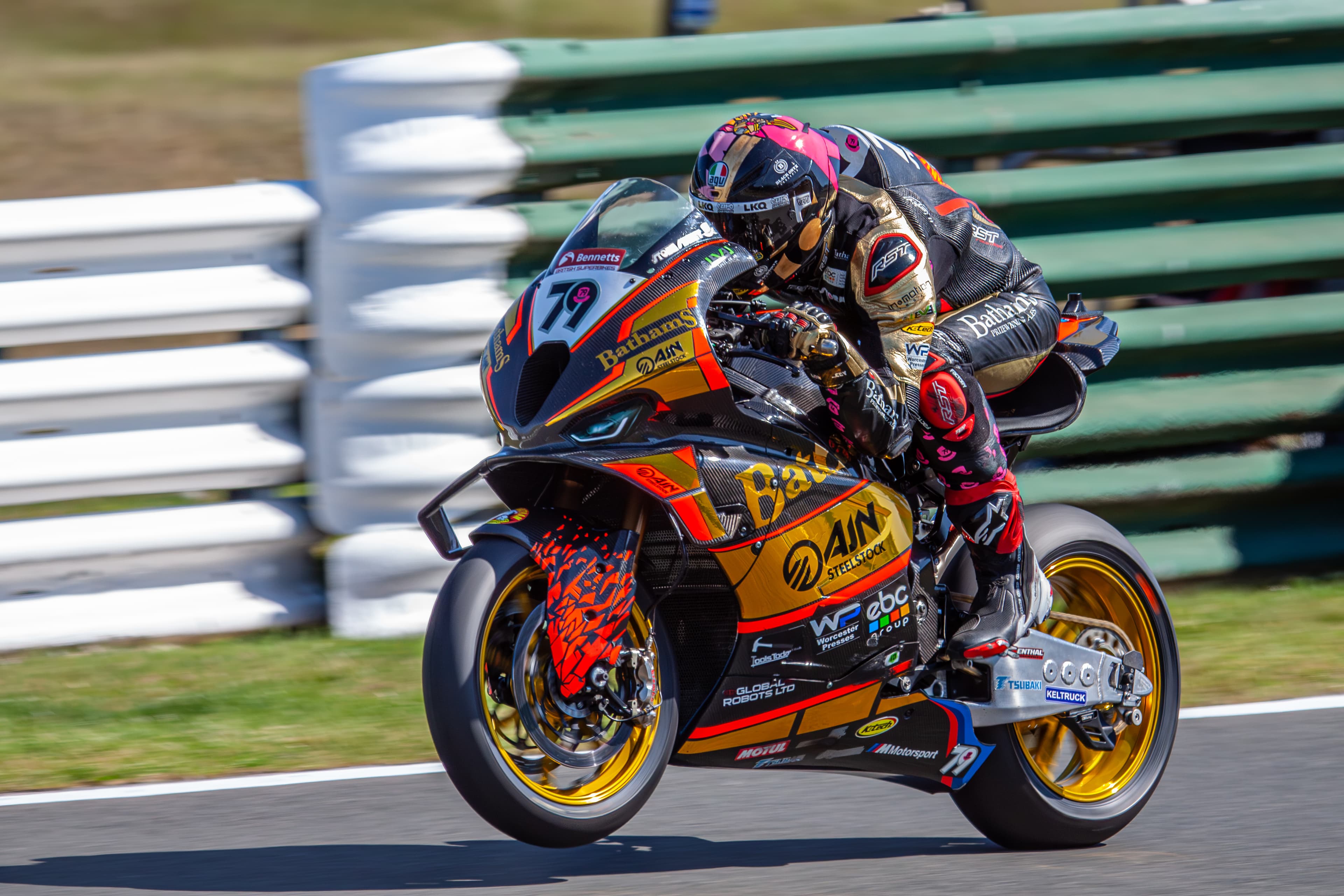 Motorcycle racer accelerating down a long straight at speed.